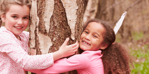 Two girls hugging a tree