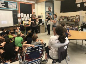 Student listening to two students playing the violin