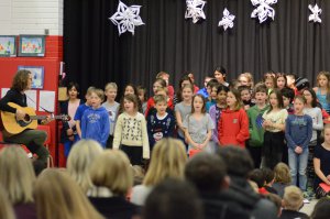 Teacher with guitar and students singing