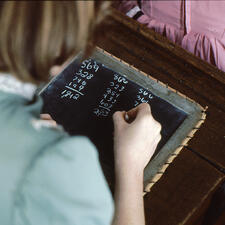 Student writing on chalk board