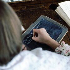 student writing on chalk board