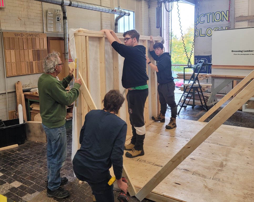 Students erect wall of tiny home.