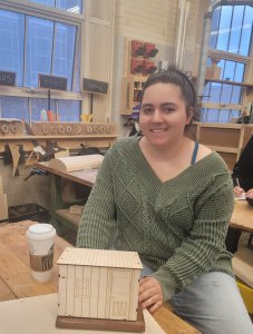 Student with model of tiny home.